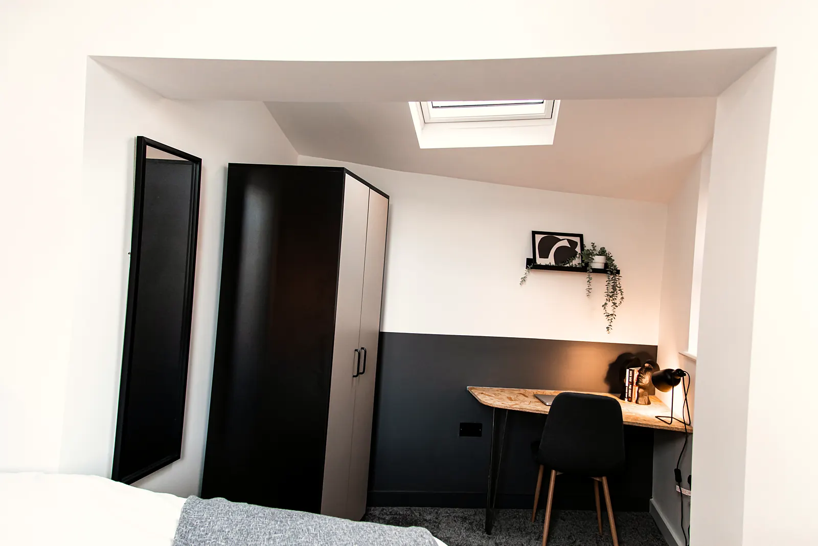 Row of desks and black wall lights at a work area in a house share